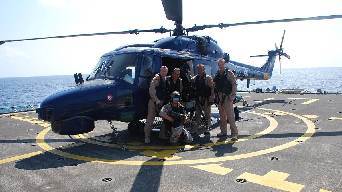 Helikopterpilot og soldater på krigsskib